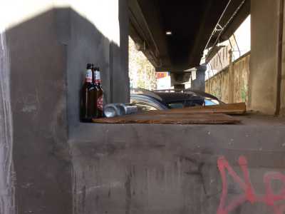 Bottiglie e lattine di birra vuote lasciate sotto il cavalcavia